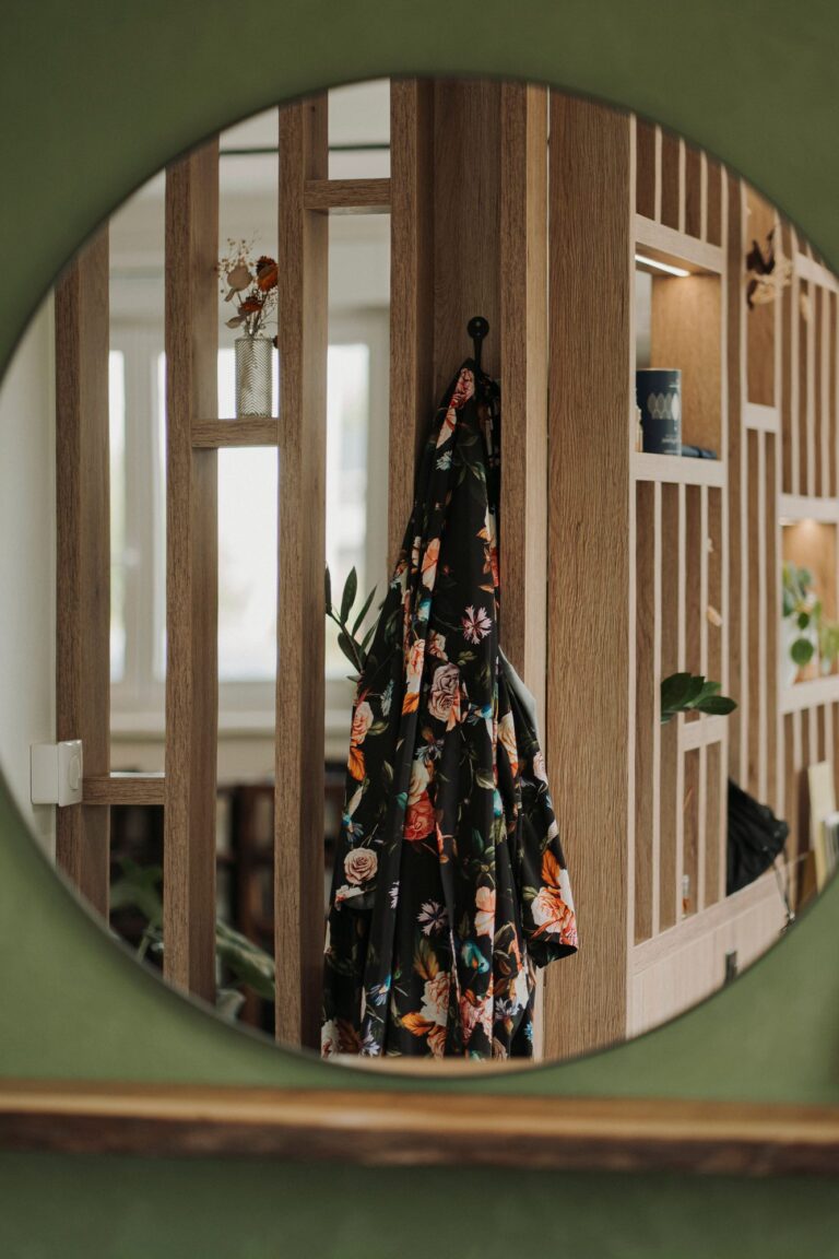 Peignoir fleuri reflété dans un miroir rond du salon